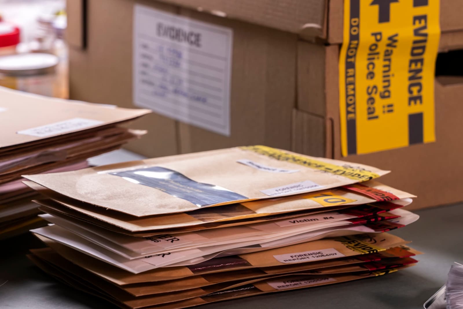 Stacks of sealed evidence envelopes and paperwork beside a box marked Evidence