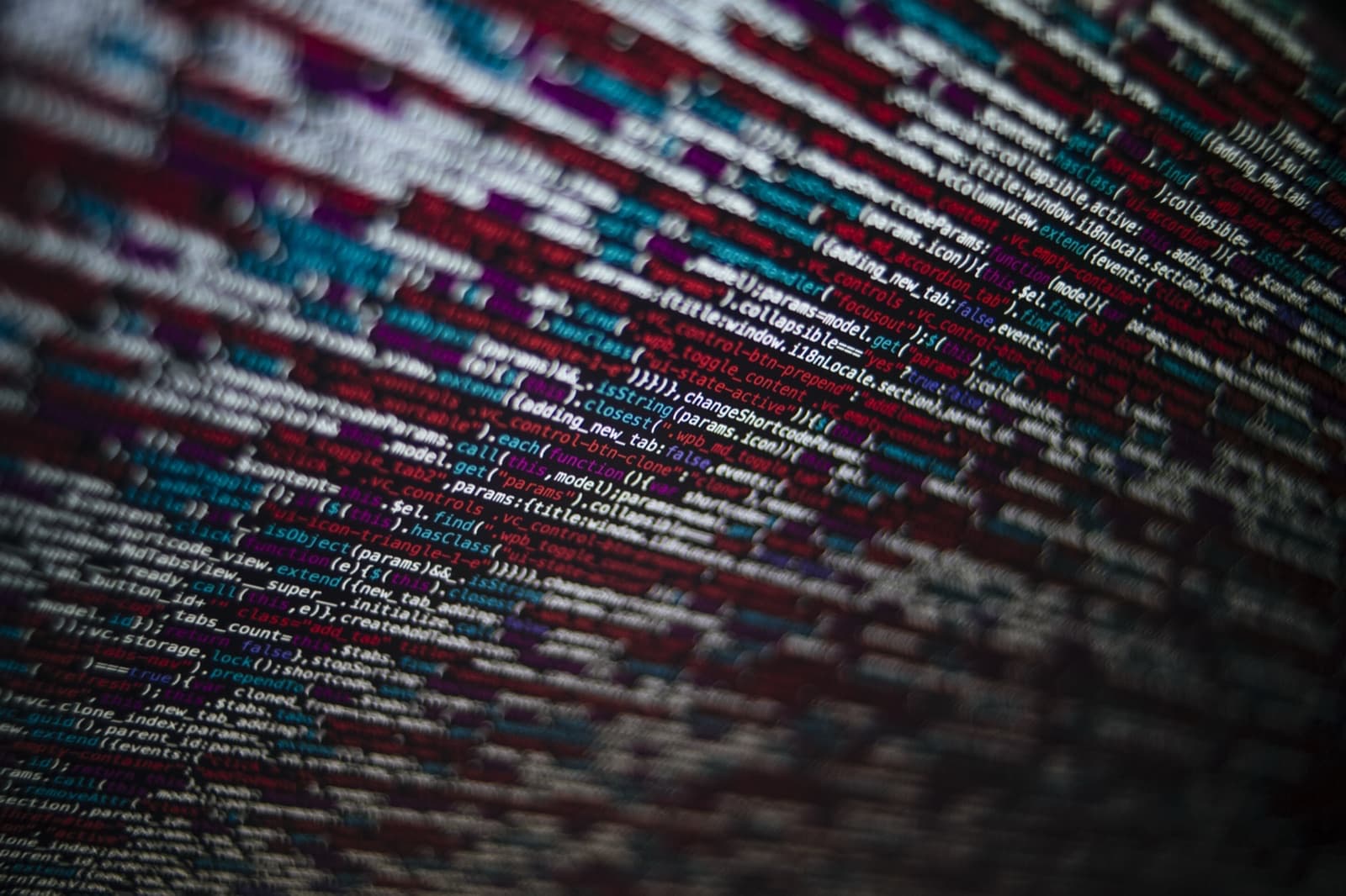 Dense lines of code on a screen, seen at a steep angle so the text falls away out of focus